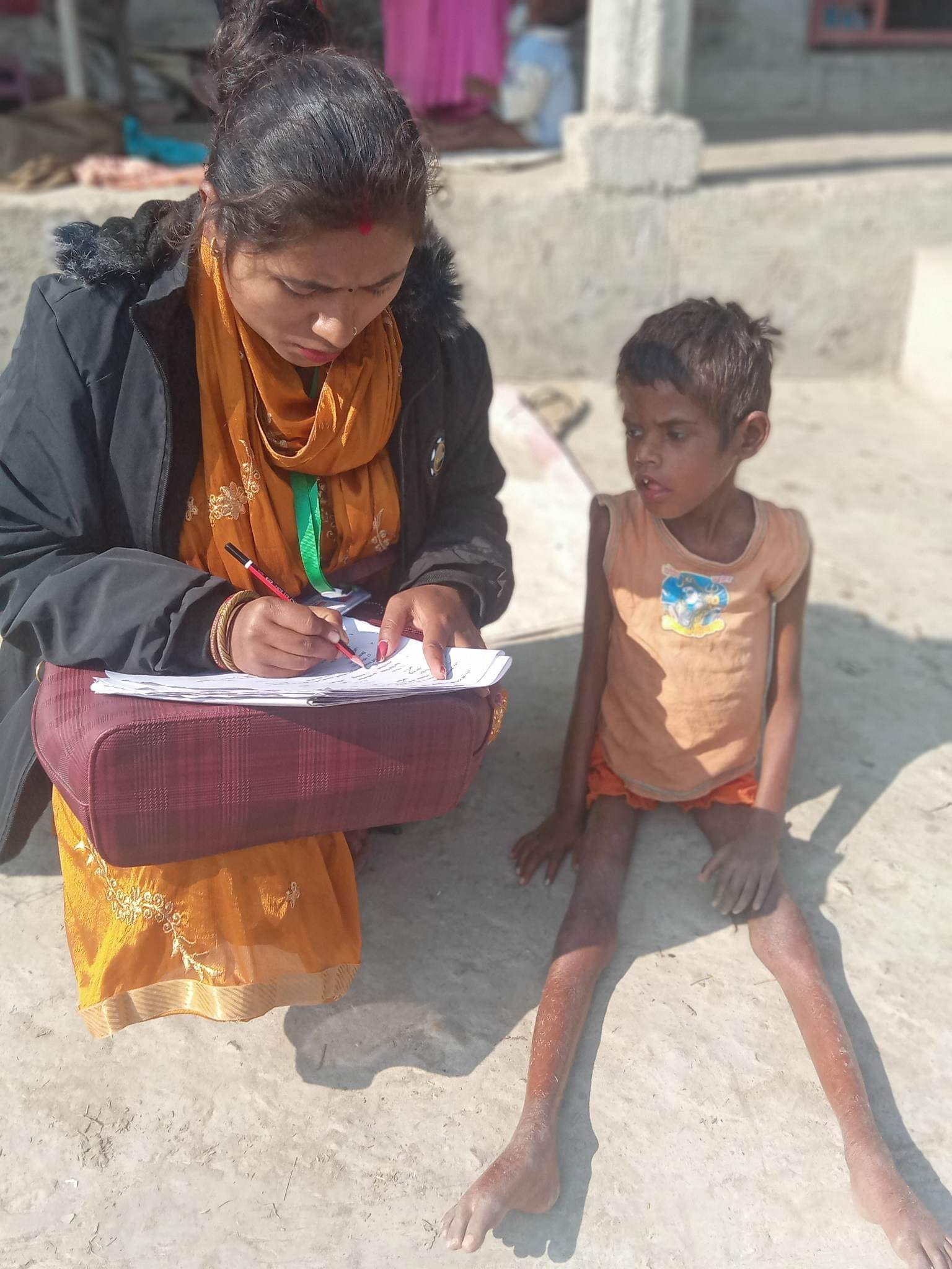 ddf staff talking with a disabled child and filling out a form